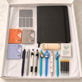 Nurse stationery gift box contents in white box including black journal, stethoscope notebooks, assorted pens, pen refills and pocket hug