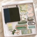 Green corduroy journal gift box in white box showing olive-green corduroy notebook with dark teal panel, white pens, butterfly sticky notes, encouragement cards, pocket hug keepsake, sage correction tape, floral accessory case, decorative pens, dragonfly keychain, page markers and green paperclips