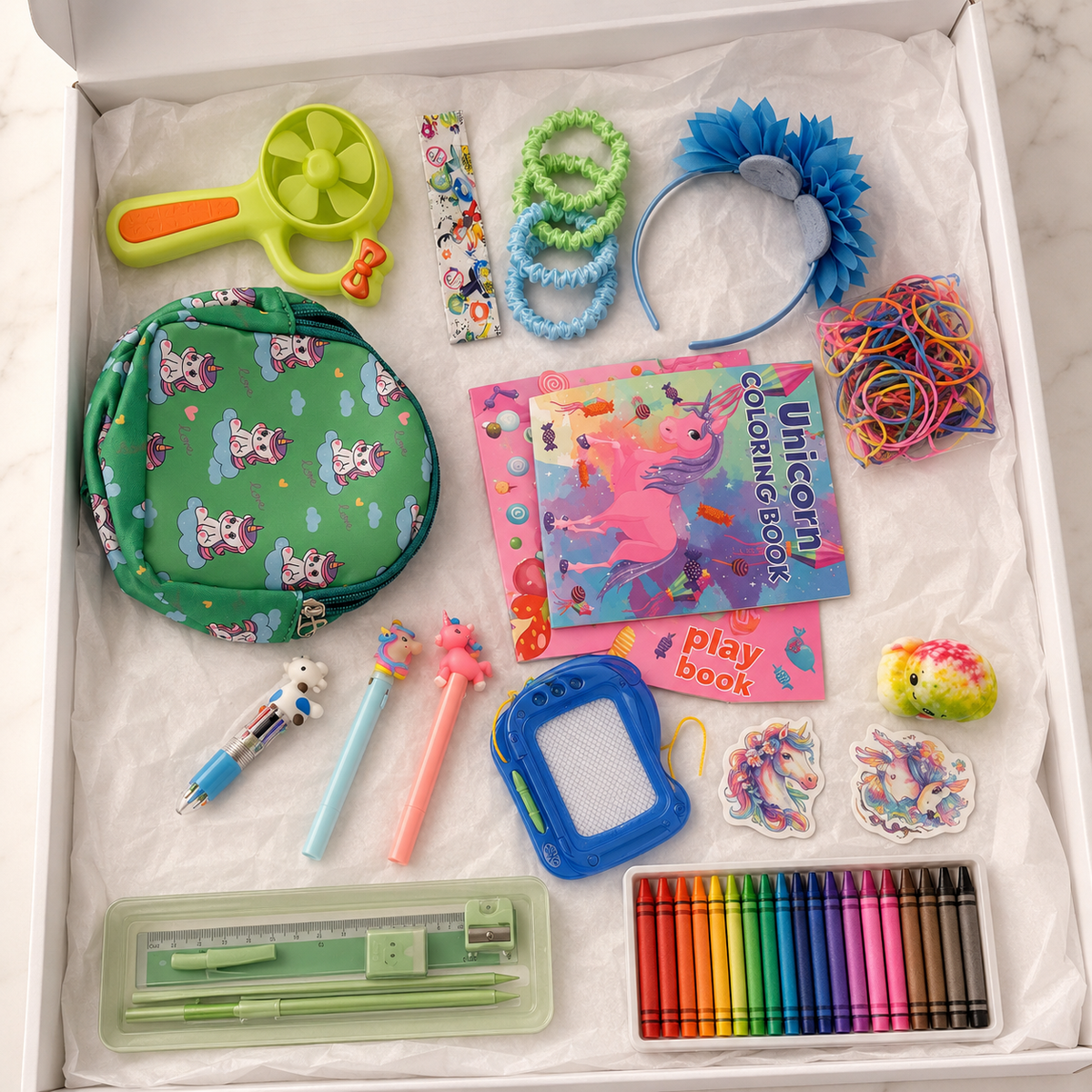 Green unicorn activity gift box in white box showing unicorn mini bag, lime-green hand fan, unicorn coloring book, candy activity book, crayons, mint pencil set, magnetic drawing board, character pens, blue flower headband, hair ties, elastic bands, stickers and sensory toy