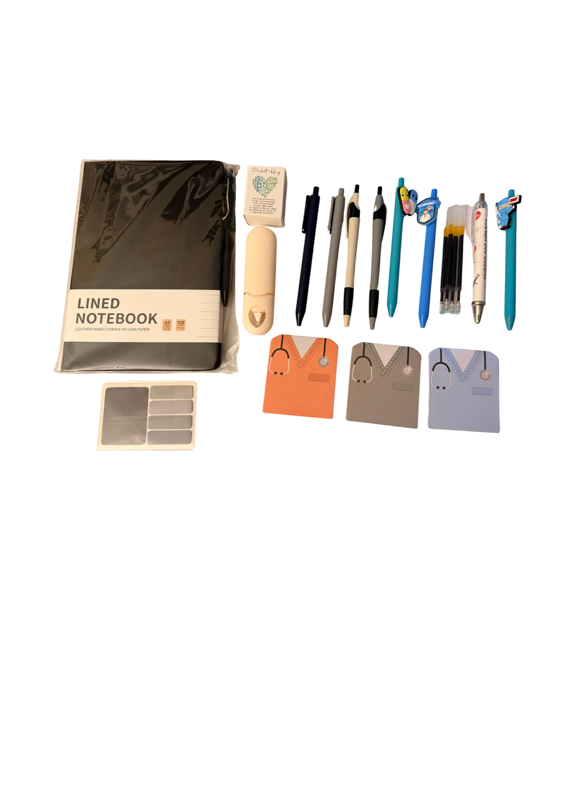 Nurse stationery gift box flat lay showing all items including lined notebook, pens, scrubs-design notebooks and page flags