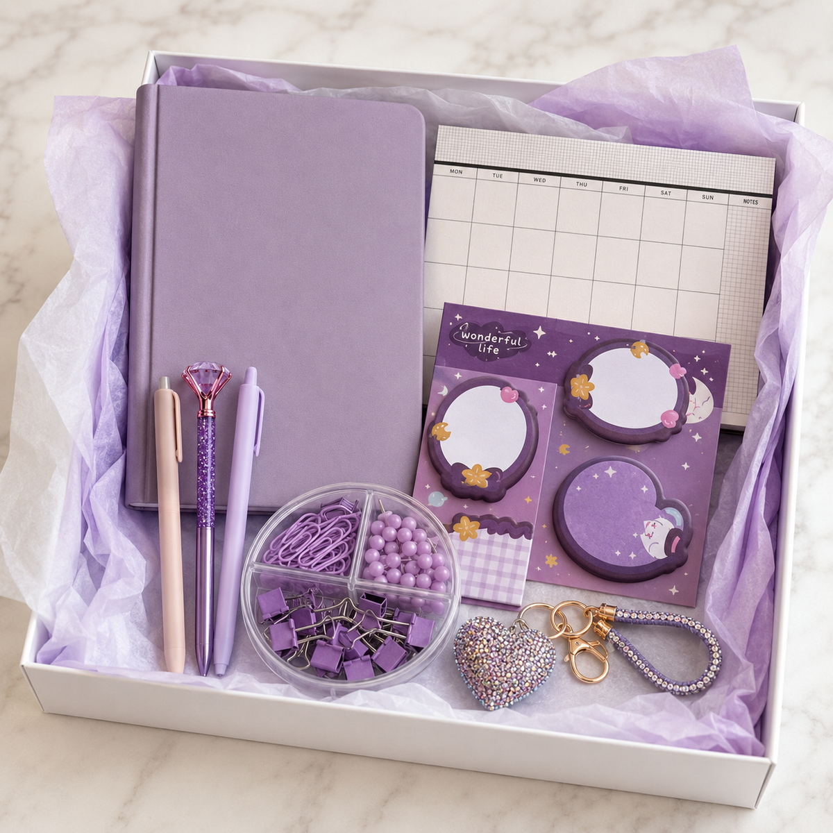 Pastel lavender stationery gift box in white box with lavender tissue paper showing notebook, weekly planner, cat memo notes, pens, clip organizer and rhinestone keychain